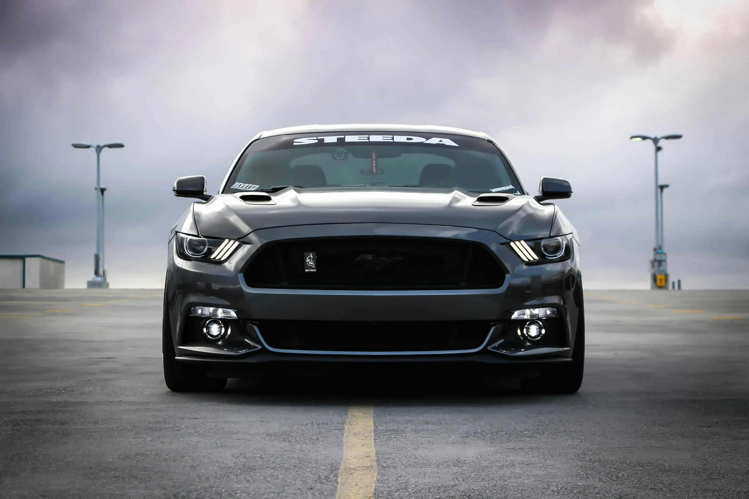 Schwarzer Ford Mustang frontal auf Parkplatz