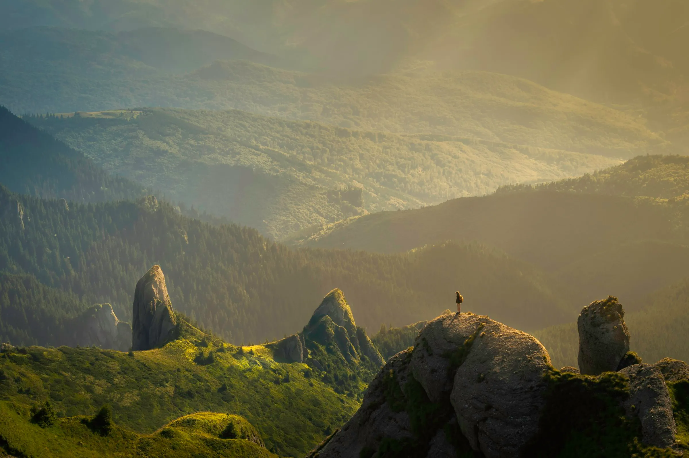 Ein Wanderer steht auf einem Felsen über einem nebligen Tal