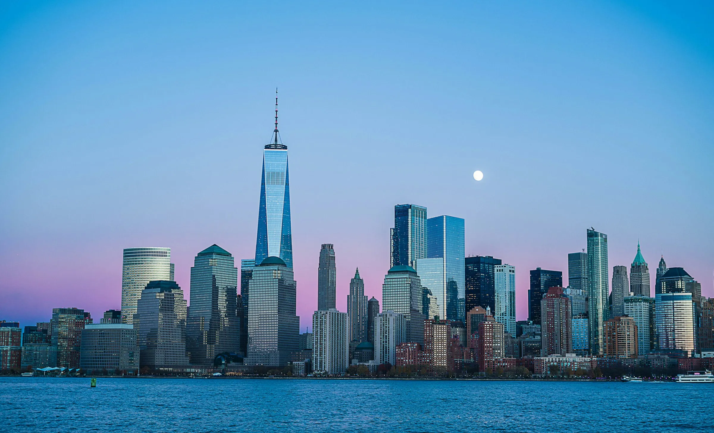 Skyline von New York mit One World Trade Center in der Dämmerung