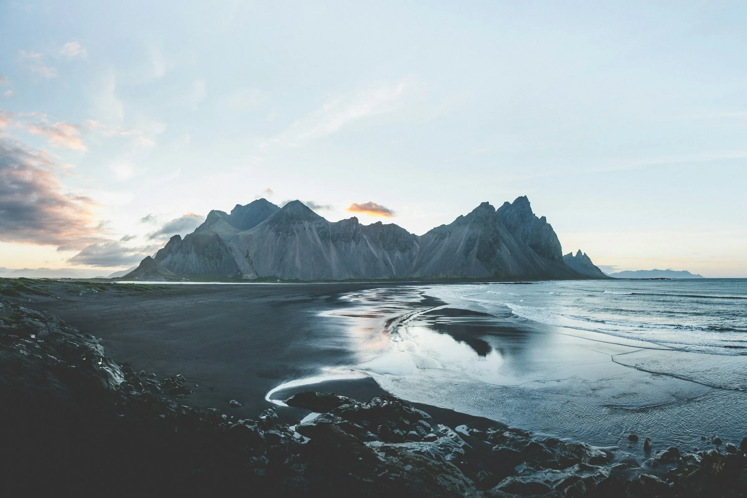 Das Vestrahorn-Gebirge in Island spiegelt sich im nassen schwarzen Sand